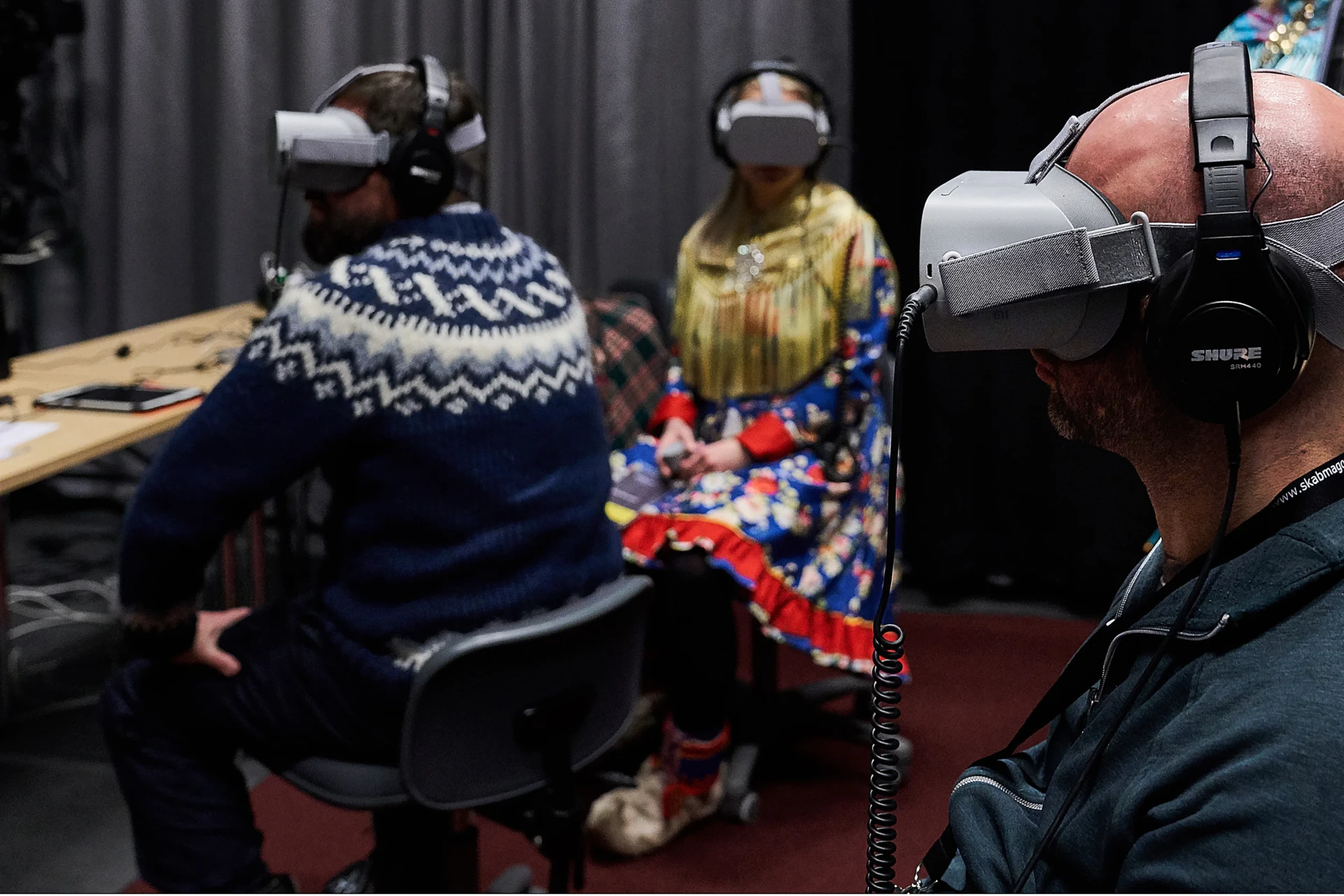 Three people wearing VR goggles.
